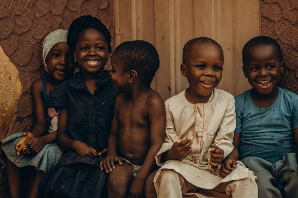 A group of African children sitting and smiling with joy and happiness.